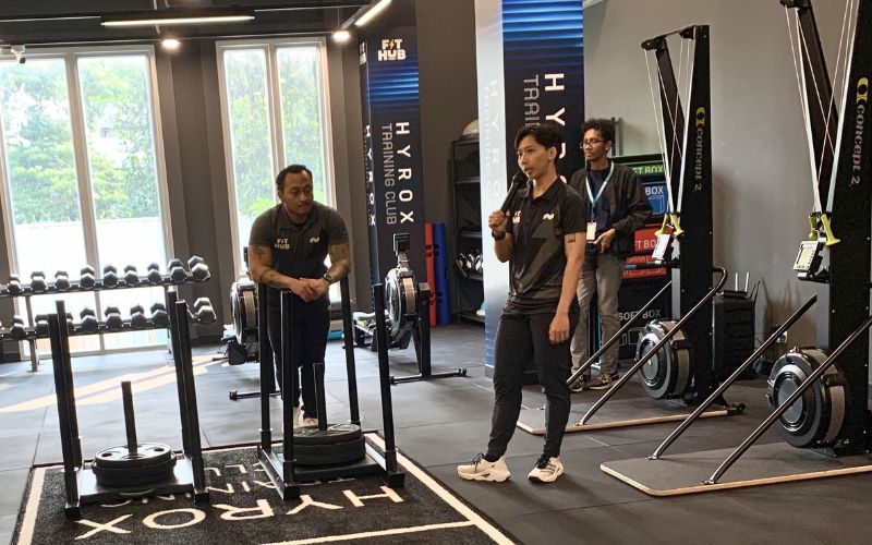 Salah satu coach memperkenalkan area HYROX yang dilengkapi fasilitas latihan fungsional di FIT HUB Kemang.